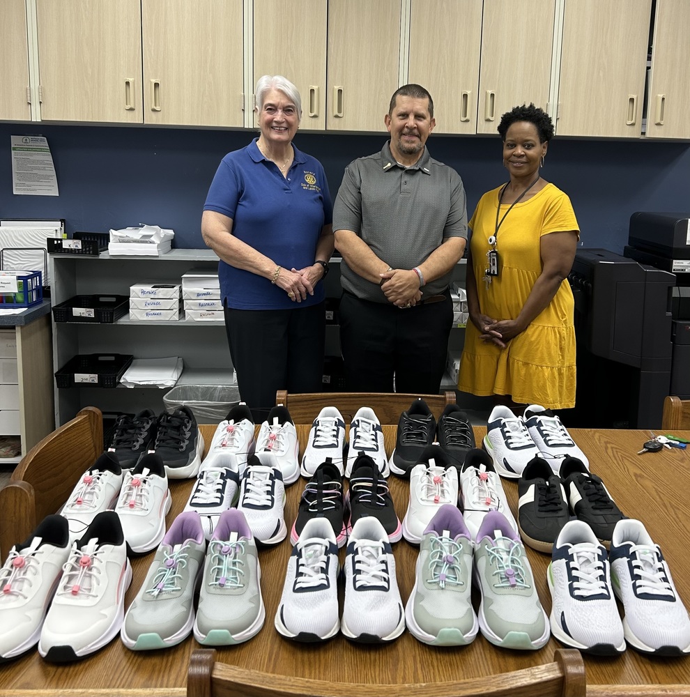 picture of two women with a man in the middle and 15 pairs of new shoes