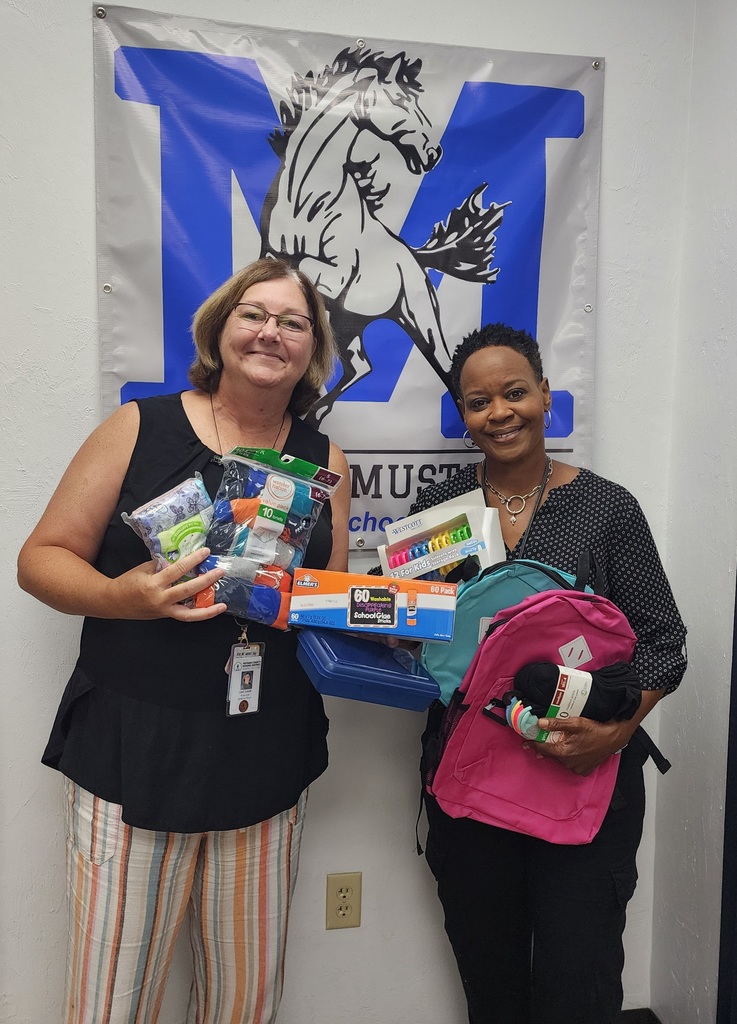  Picture of Principal and Asst. Principal holding supplies donated from Hope FM donation.