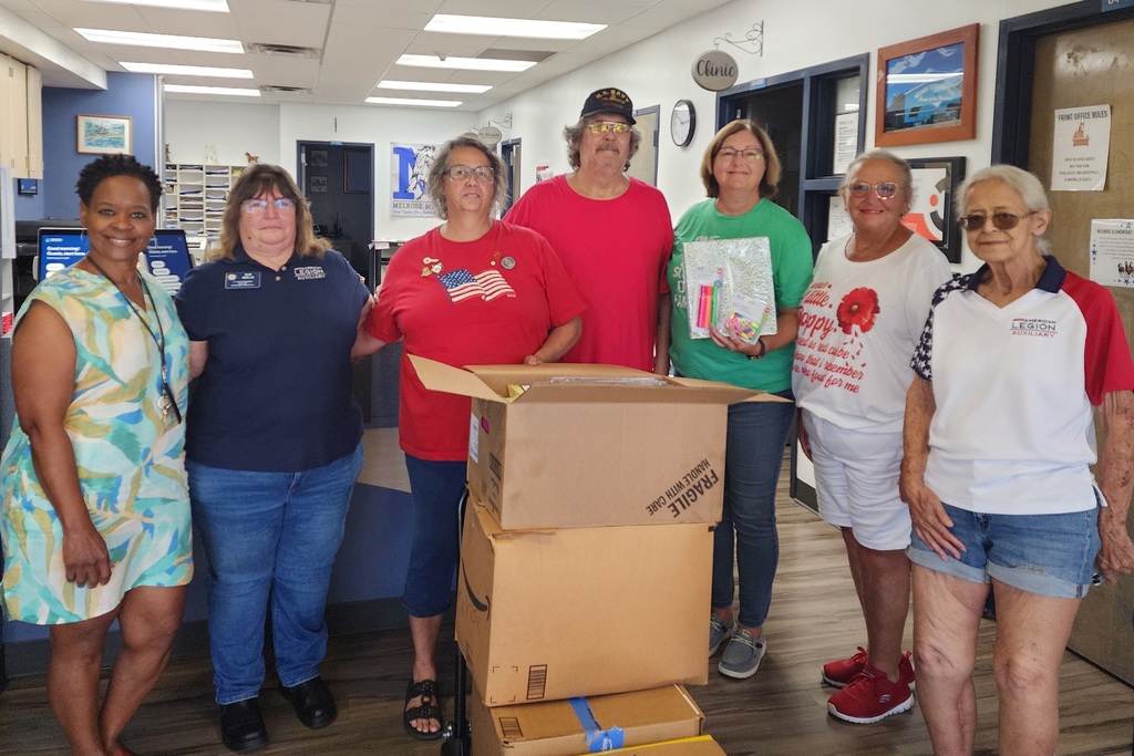 Picture of 7 people holding school supplies that were donated to the school from the American Legion Auxillary from Keystone.