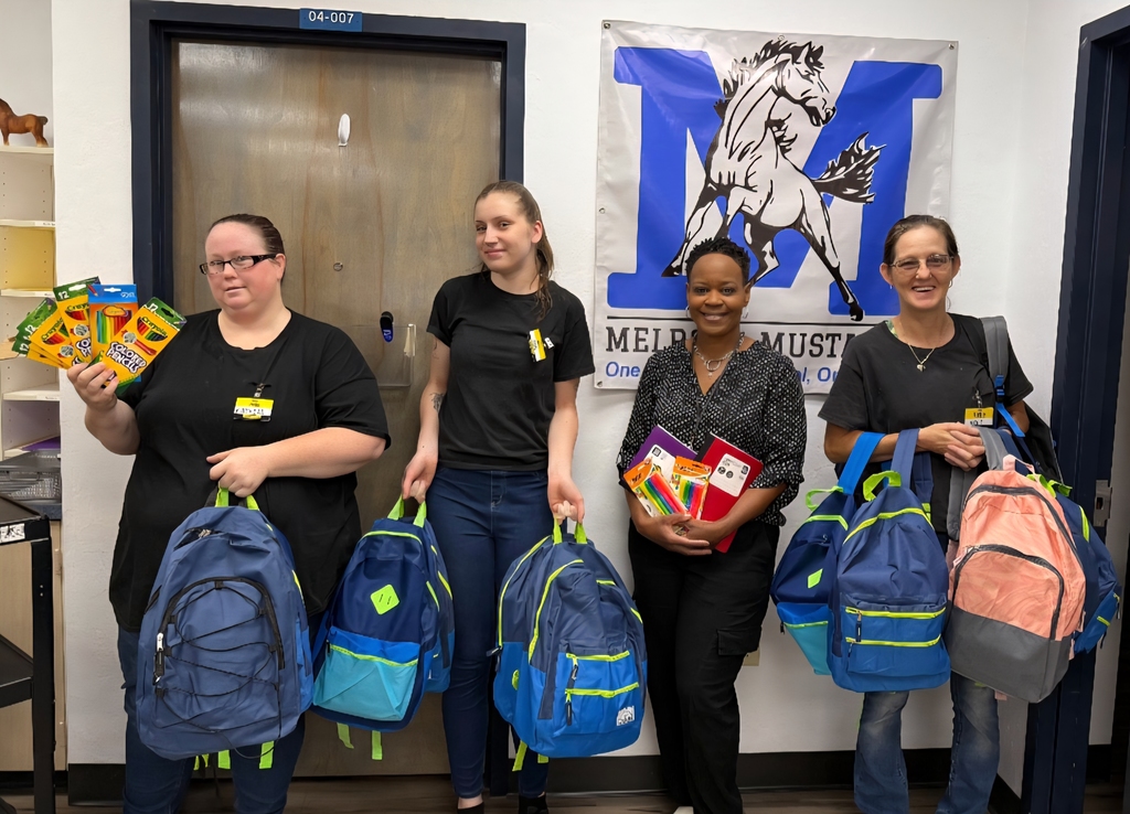 Picture of 4 ladies holding school supplies donated from Dollar General, Melrose.  