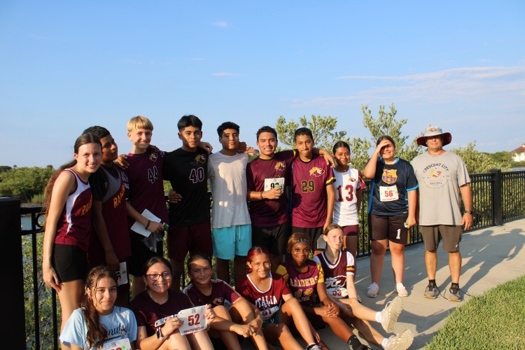 Boys and girls cross country team poses for picture with Coach Lease.