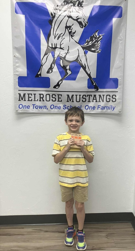 Male student holding a gift card under the Melrose Sign