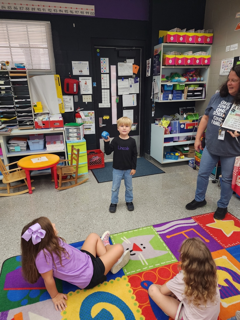 students sitting on floor rolling dice