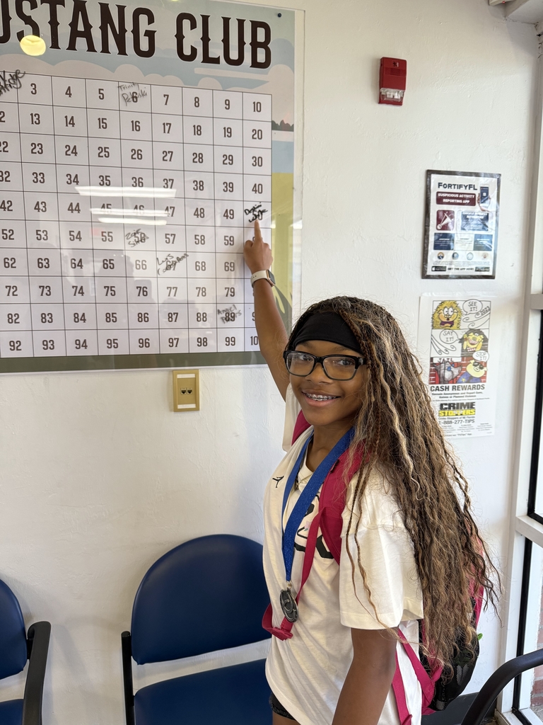 picture of female student pointing to Mustang Club board.