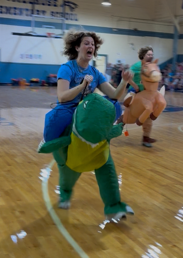 Teacher in dinosaur costume running. 