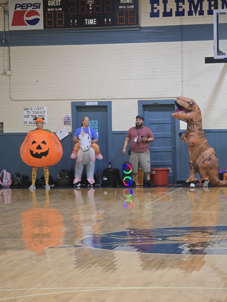 Group of teachers in costumex (pumpkin, dinasour, unicorn) ready to race.