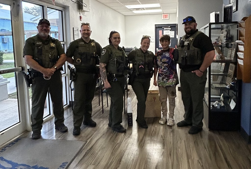 Picture of student with 5 sheriff deputies.
