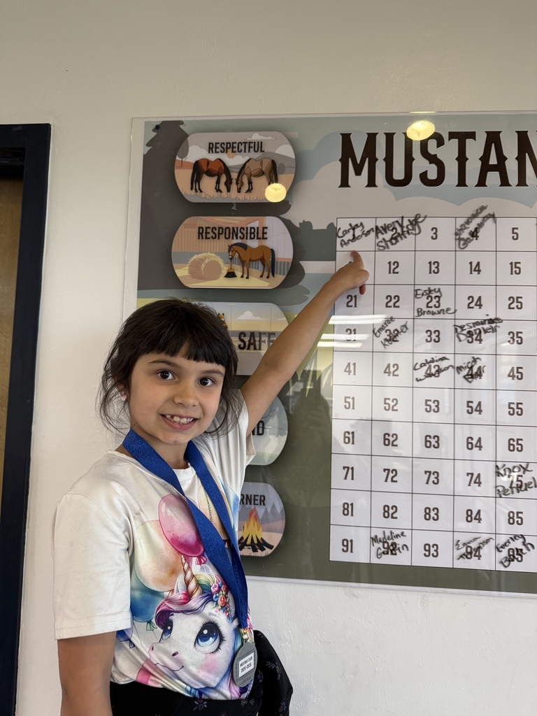 picture of female student pointing at the Mustang Club board
