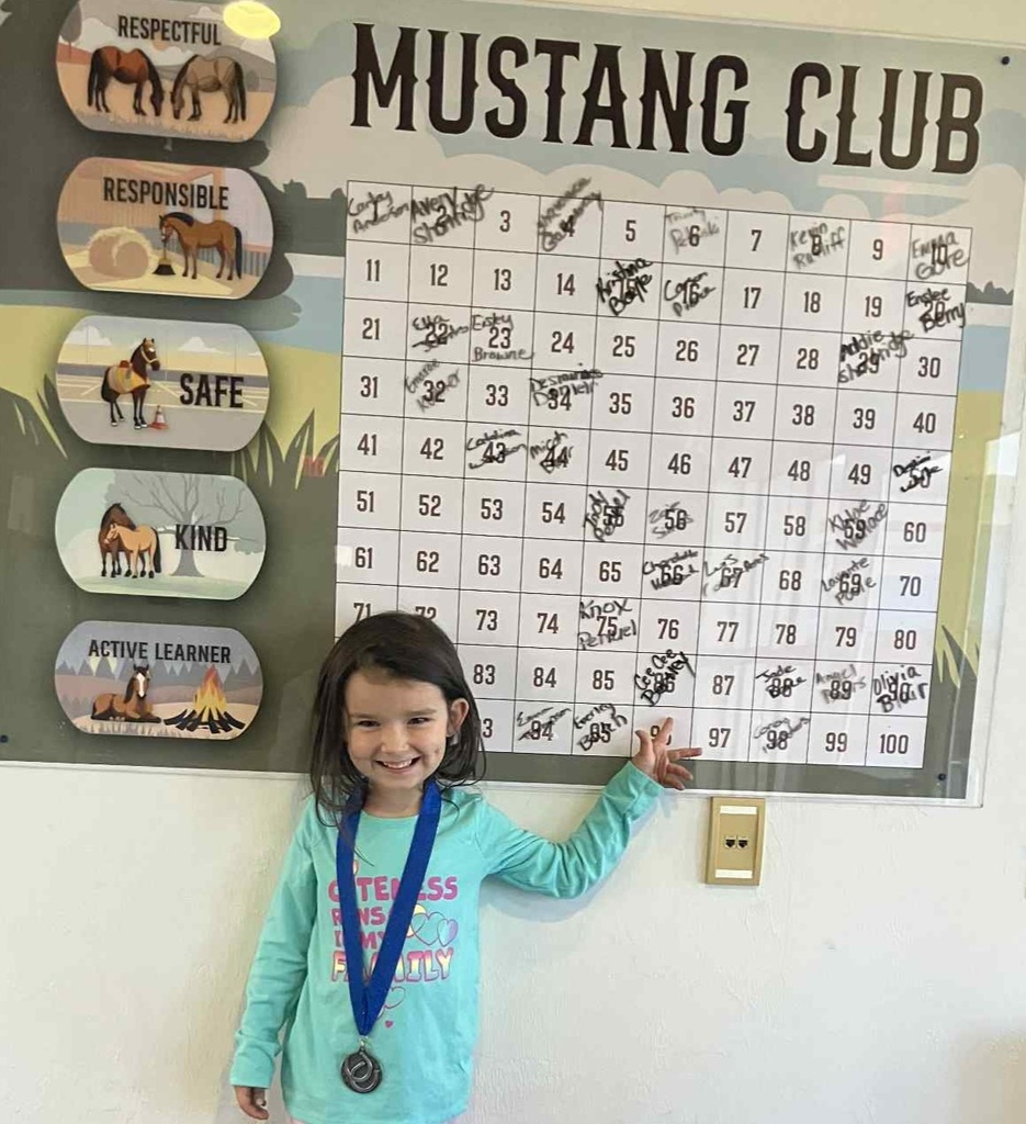 Picture of female student pointing at the Mustang Club board.