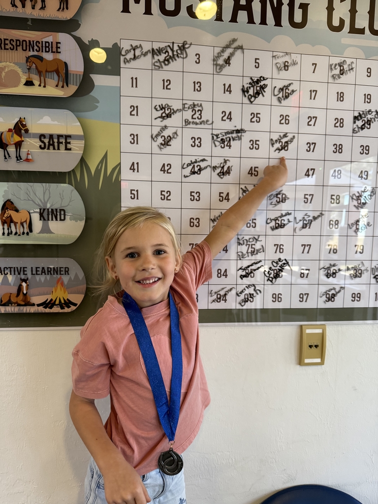 picture of female student pointing at Mustang Club board 