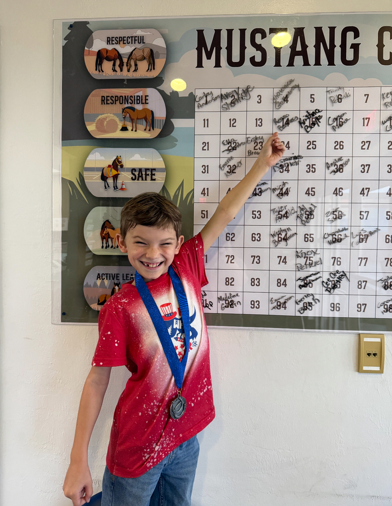 picture of male student pointing to Mustang Club board 