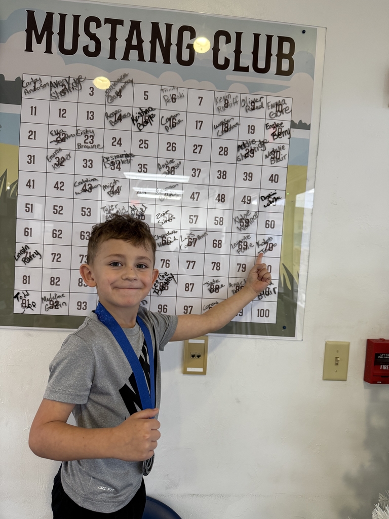 picture of male student pointing at Mustang Club board