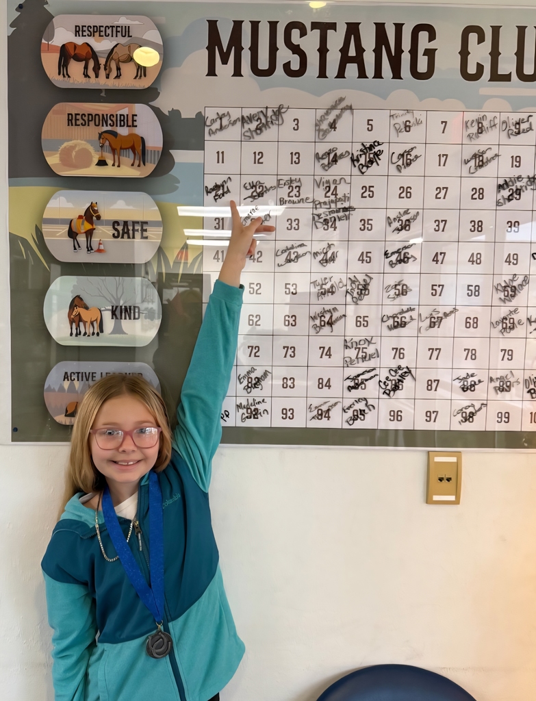 picture of female student pointing to Mustang Club board