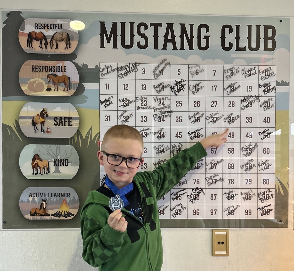 picture of male student pointing at Mustang Club board