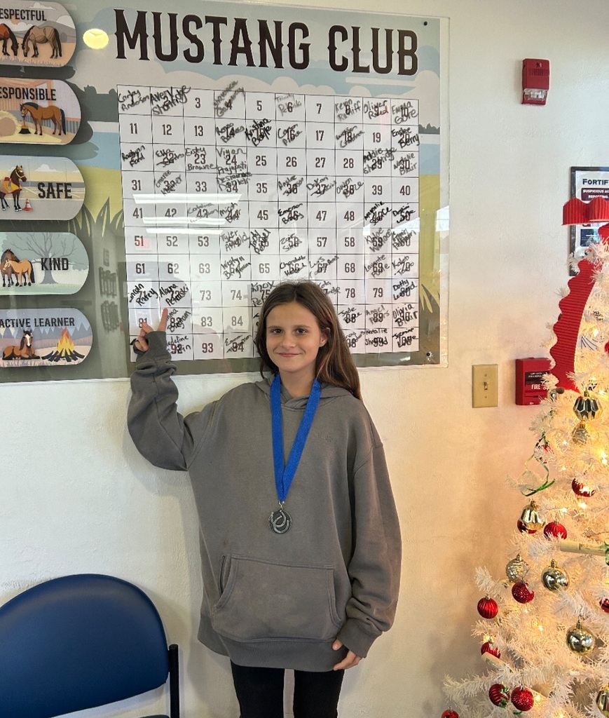 picture of female student pointing to Mustang Club board