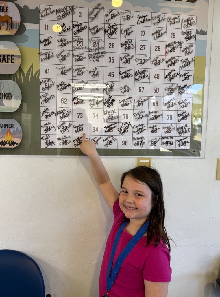 Picture of female student pointing at the Mustang Club board.