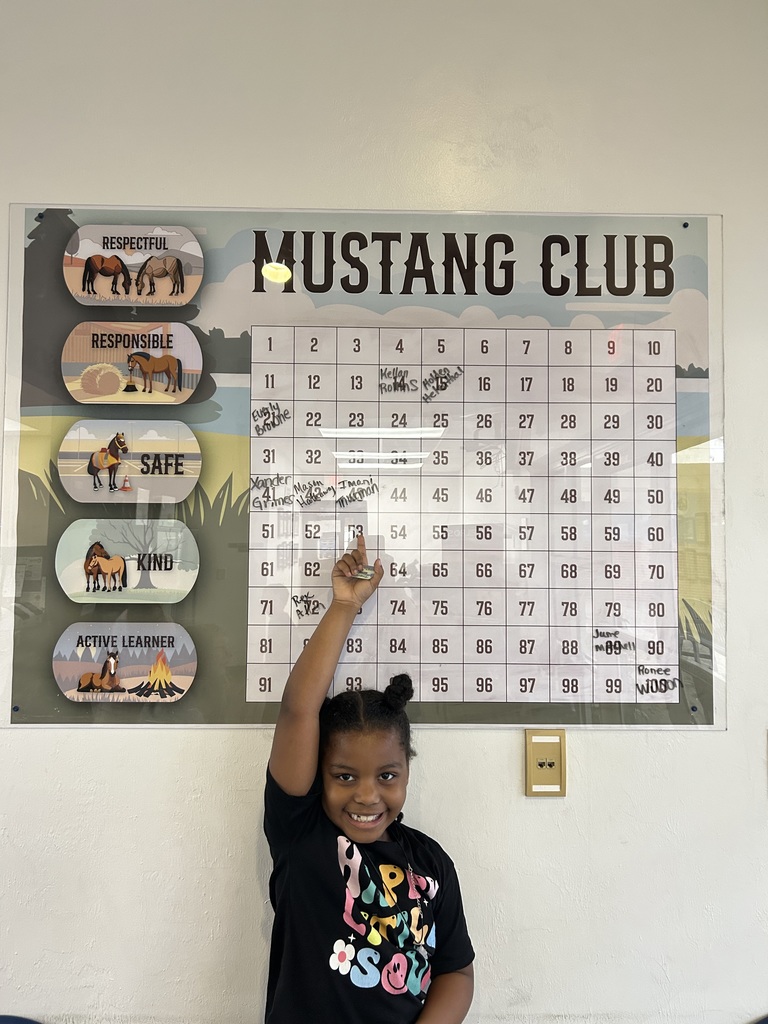 Picture of female student pointing at Mustang Club board 