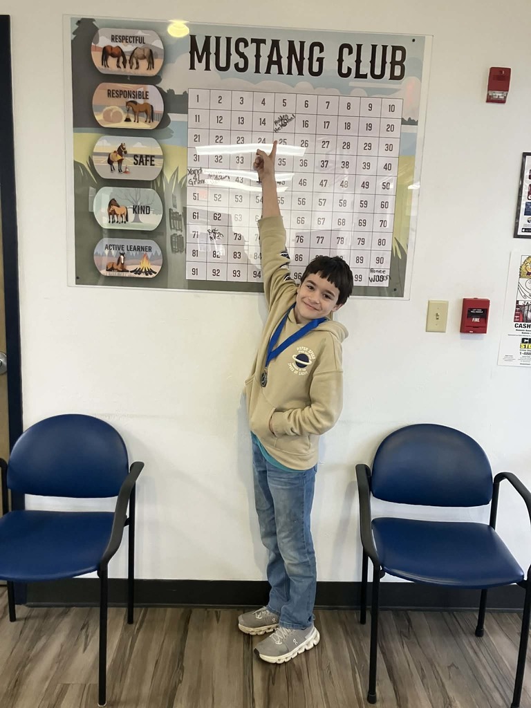 Picture of male student pointing at Mustang Club board 