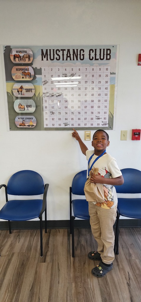 Picture of male student pointing at Mustang Club board 