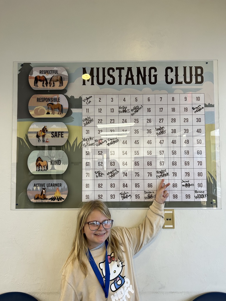 Picture of female student pointing at Mustang Club board