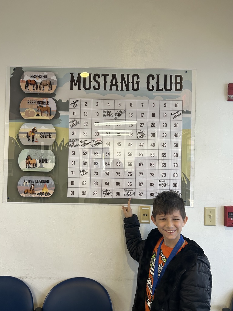 Picture of male student pointing at Mustang Club board