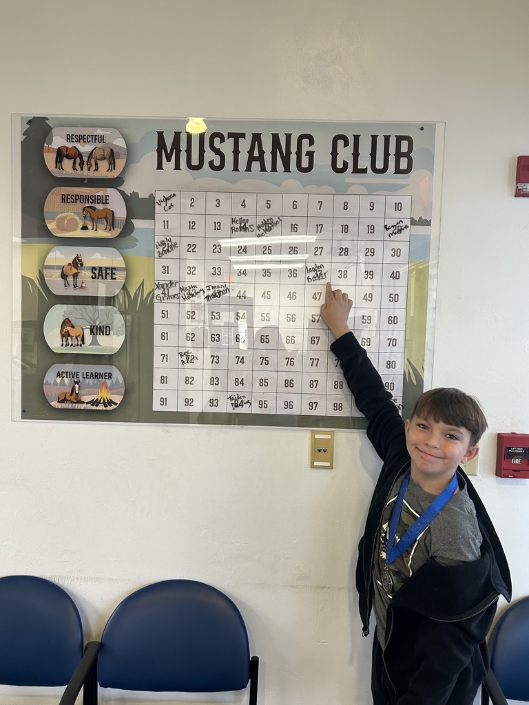 Picture of male student pointing at Mustang Club board