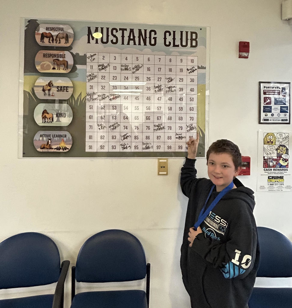 picture of male student pointing to the Mustang Club Bingo board