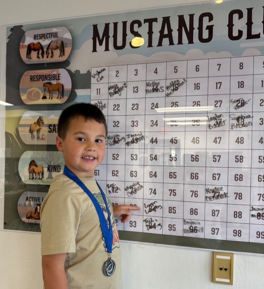 picture of male student pointing at the Mustang Club Bingo board