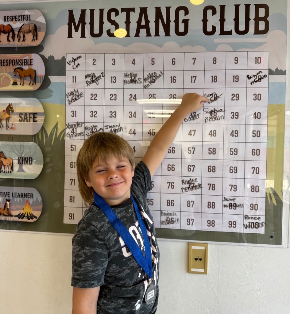 picture of male student pointing to the Mustang Club Bingo board