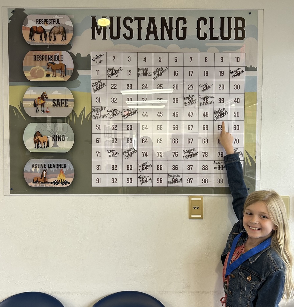 Picture of female student pointing at the Mustang Club board.
