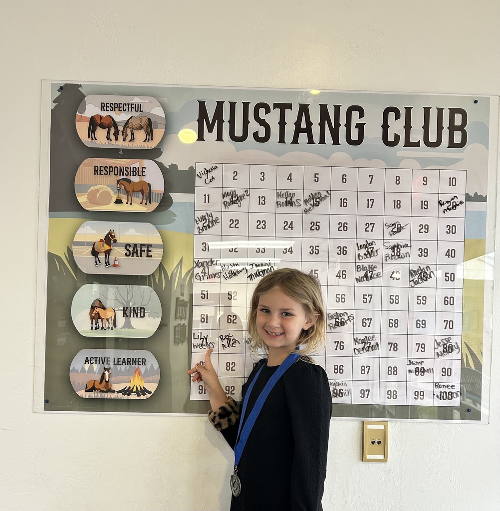 Picture of female student pointing at the Mustang Club board.