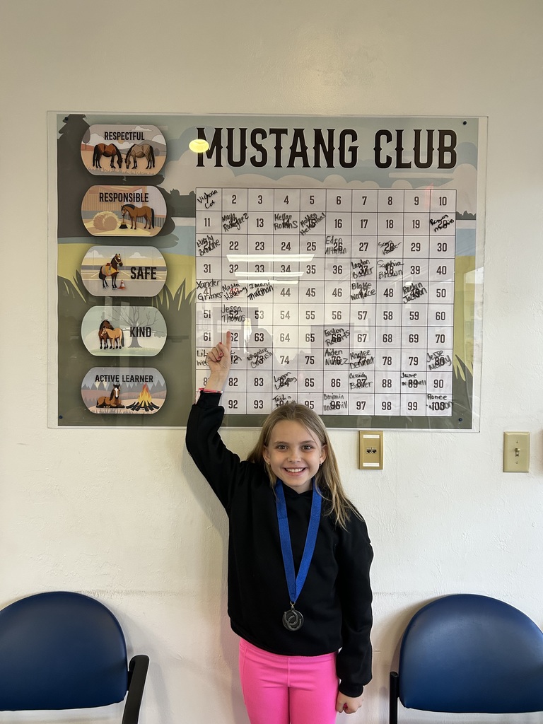 Picture of female student pointing at the Mustang Club board.
