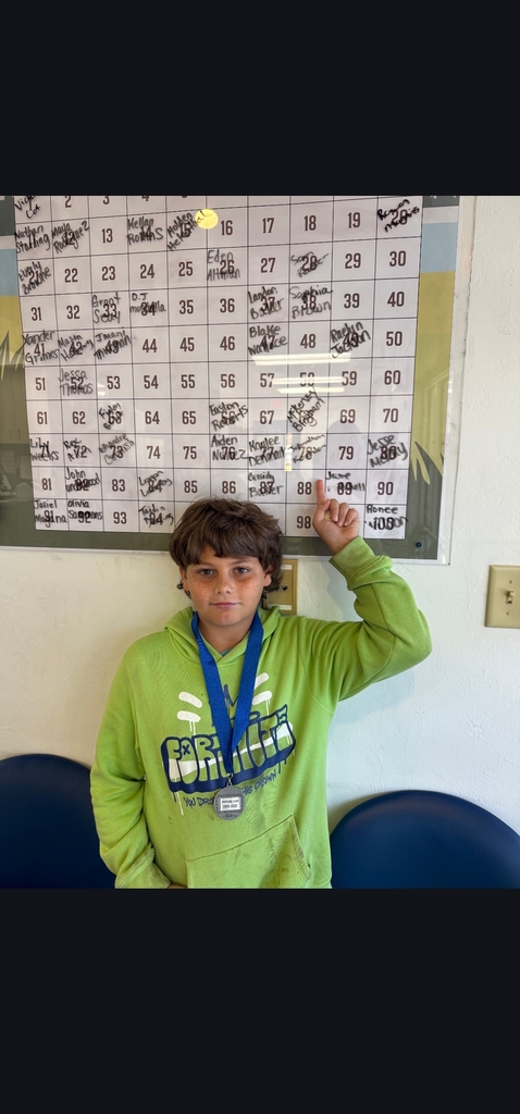 Picture of male student pointing at Mustang Club board 