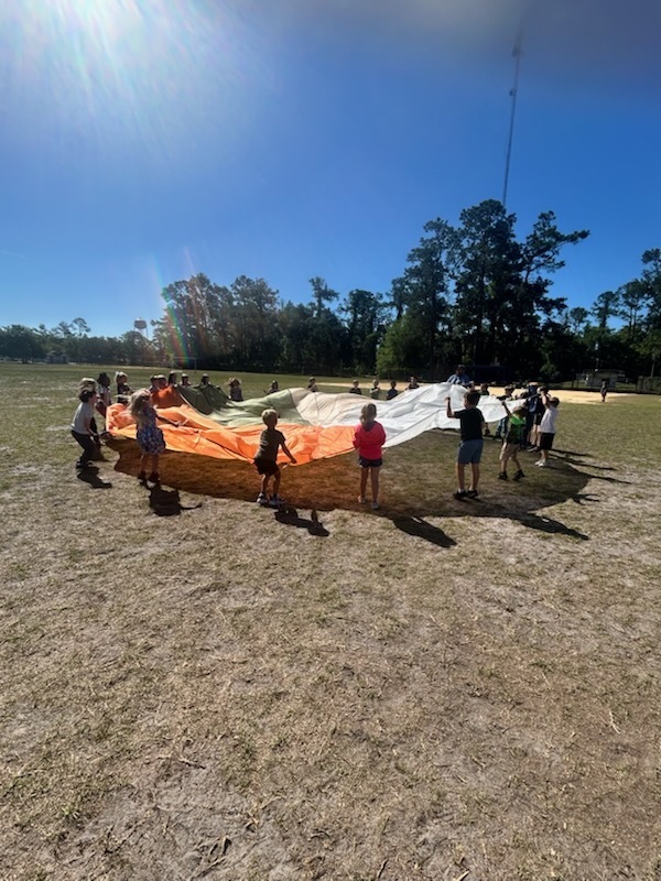 kindergarten students having fun with a parachute
