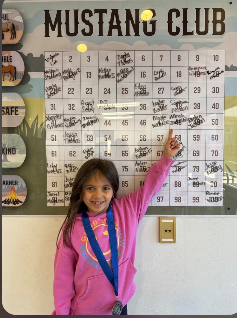 Picture of female student pointing at Mustang Club board 
