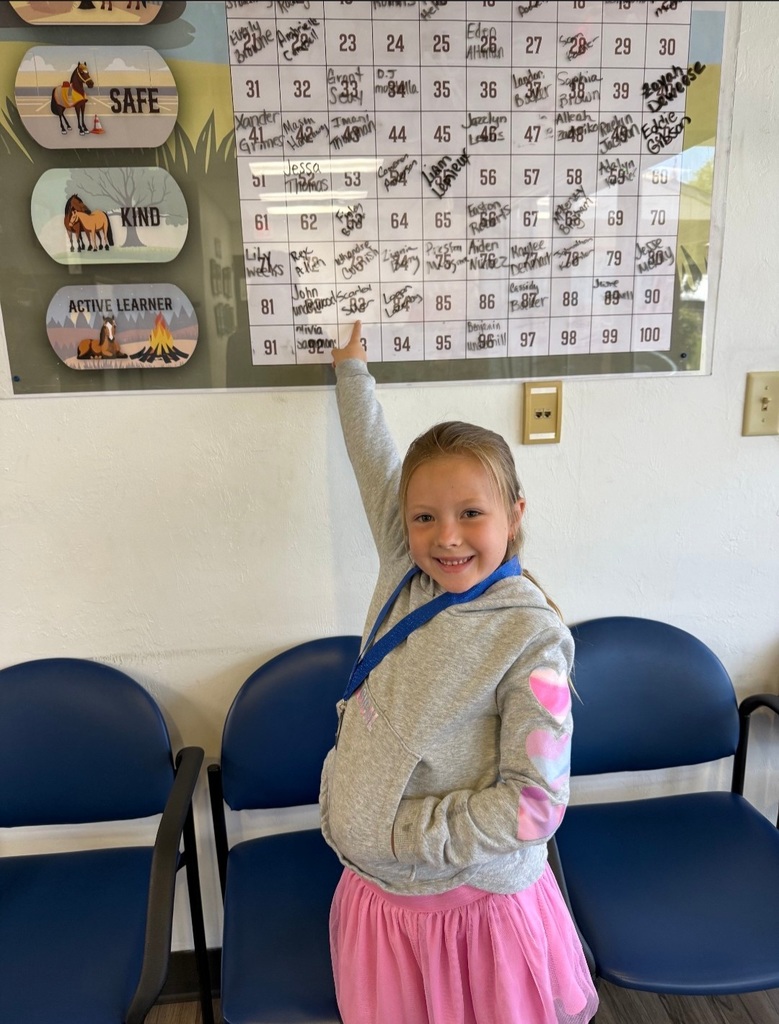 Picture of female student pointing at Mustang Club board 