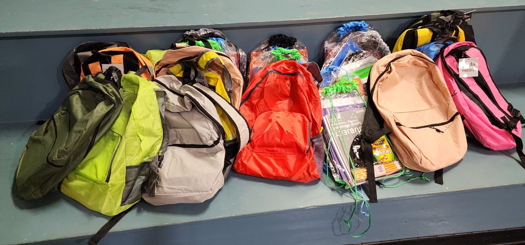 Picture of a variety of 30 backpacks full of supplies.