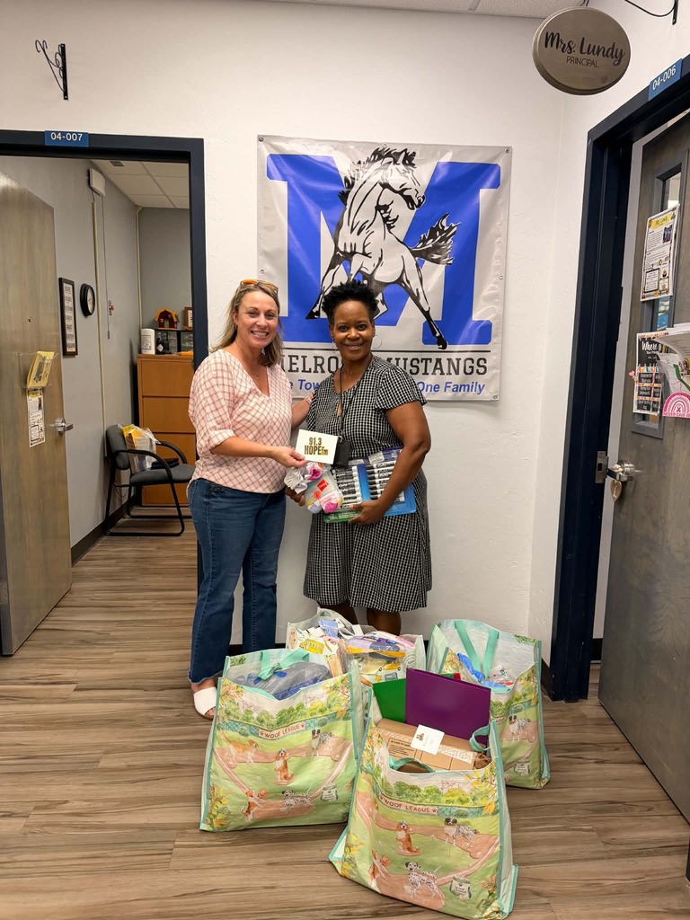 picture of two ladies at Melrose Elementary with backpacks and school supplies donated from Hope FM