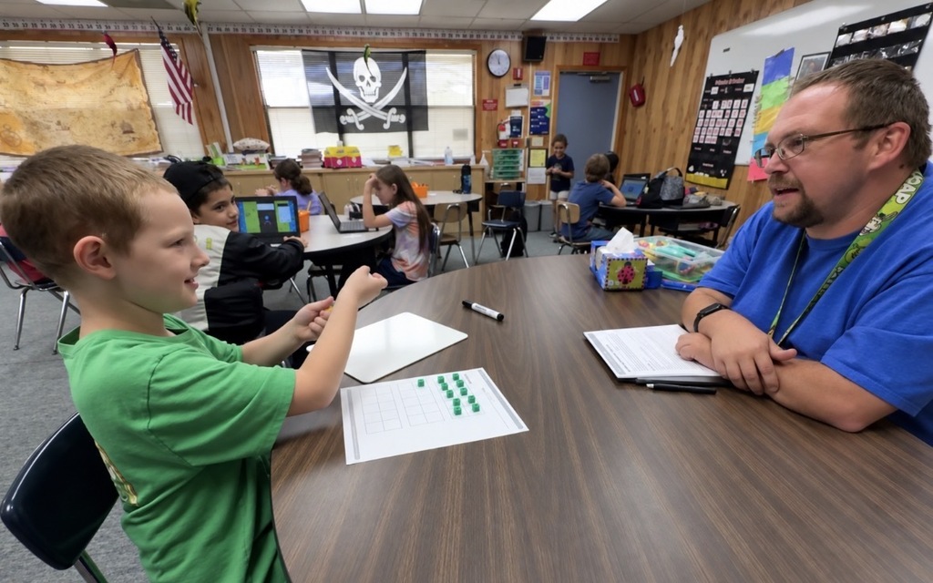 Mr. Johns working with his students in math class.
