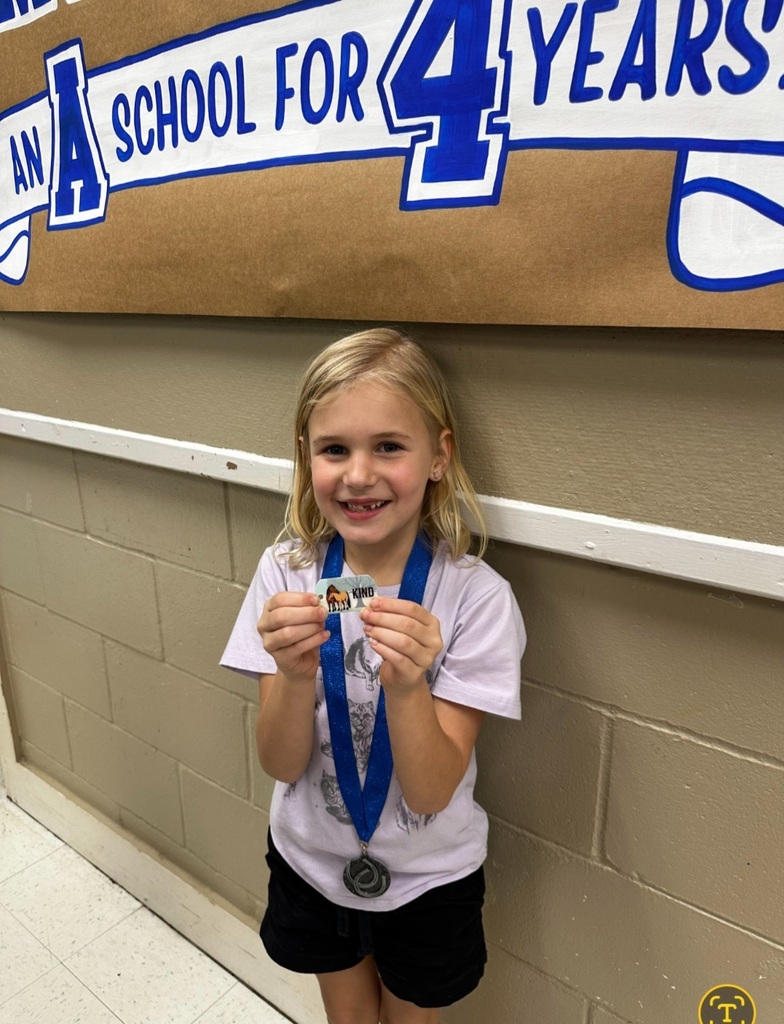 picture of female student holding up a brag tag with medal