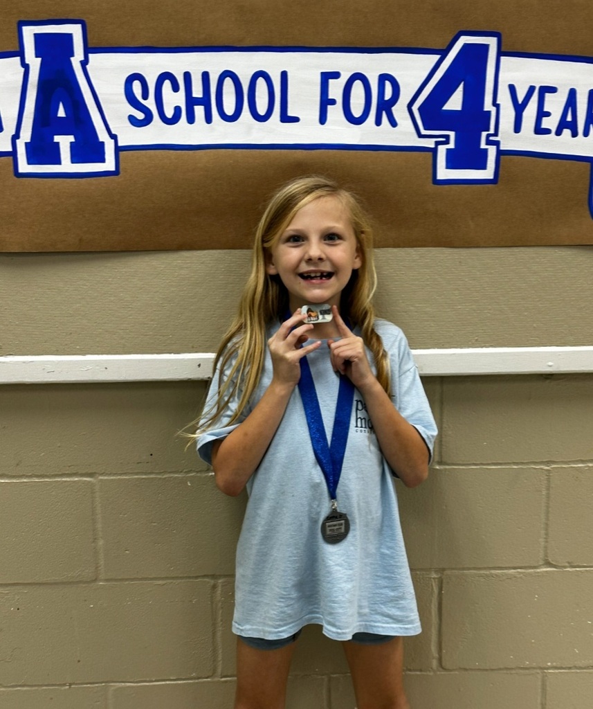 picture of female student holding brag tag with Mustang Club medal