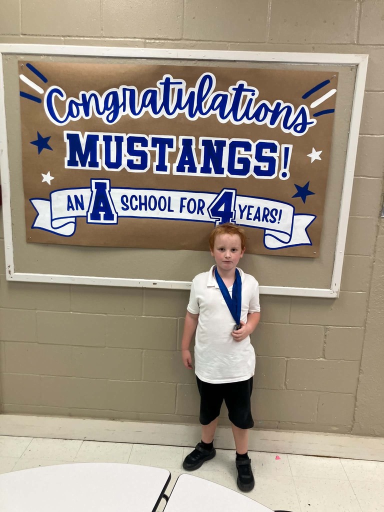 Picture of male student standing with Mustang Club medal