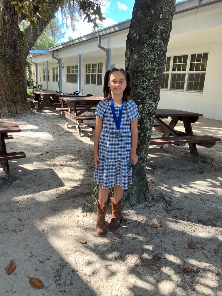 Picture of female student standing with Mustang Club medal