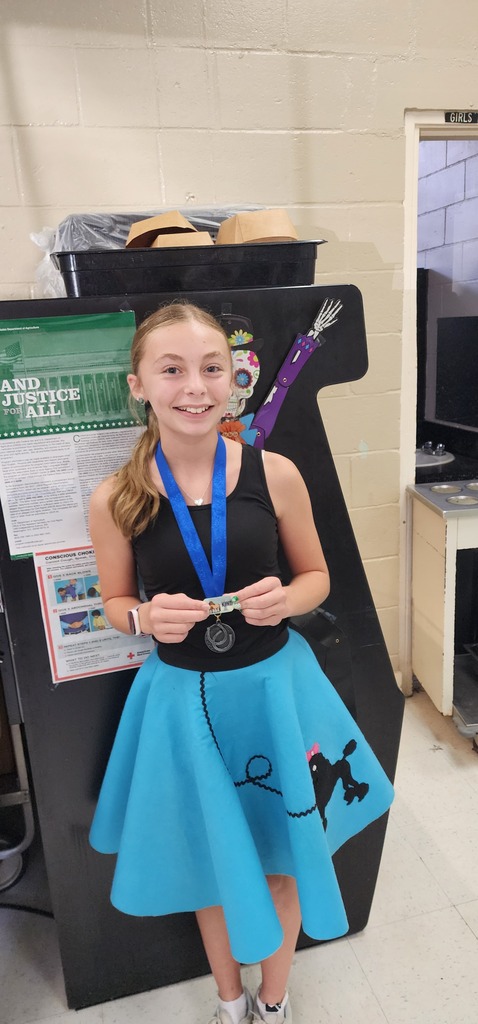 Picture of female student standing with Mustang Club medal