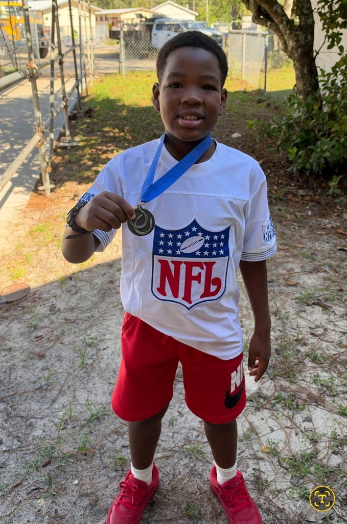 Picture of male student standing with Mustang Club medal