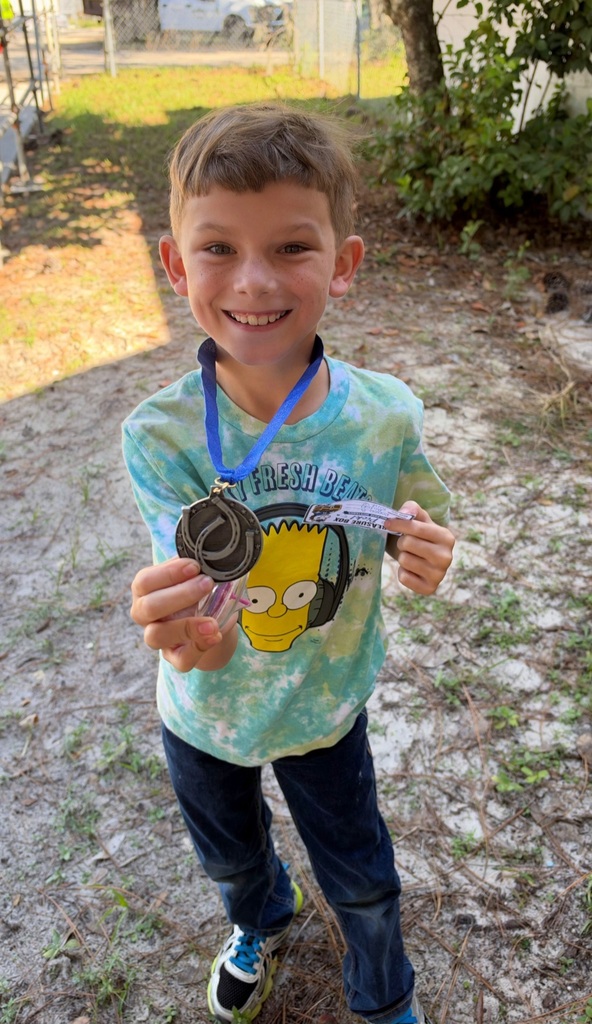 Picture of male student standing with Mustang Club medal