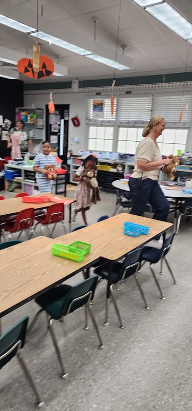 picture of kindergarten students walking in a parade with their stuffed animals.