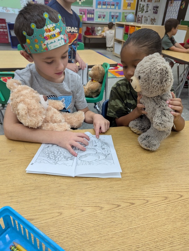 picture of two kindergarten students reading to their bears