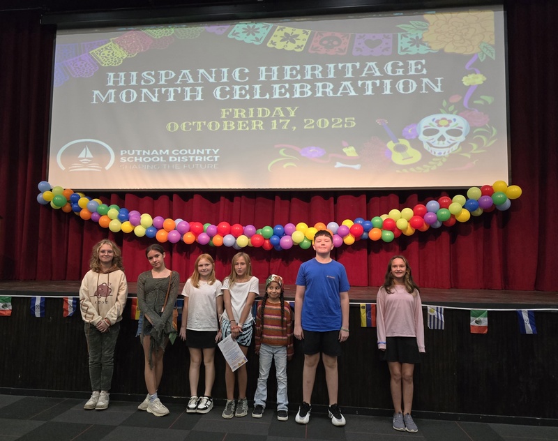 Picture of 7  students in front of screen titled Hispanic Heritage Month Celebration. 