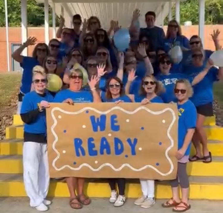 staff holding we ready sign